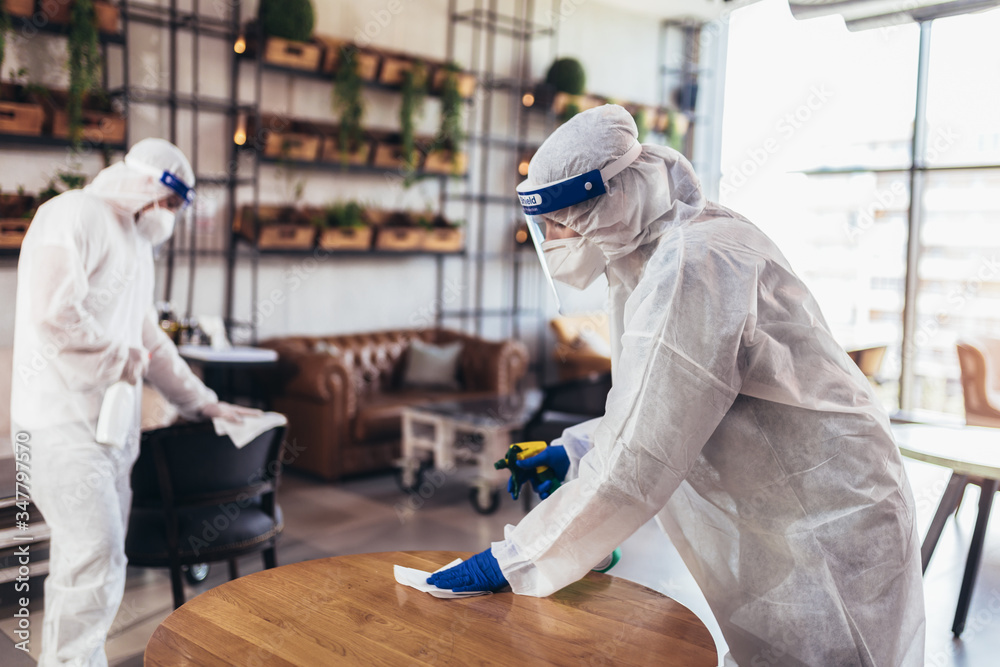 Professional workers in hazmat suits disinfecting indoor of cafe or restaurant, pandemic health risk, coronavirus - obrazy, fototapety, plakaty 