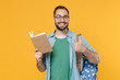© ViDi Studio - Smiling young man student in casual clothes glasses with backpack isolated on yellow background. Education in high school university college concept. Mock up copy space. Reading book showing thumb up.