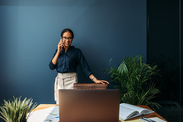 Wall Mural - Female entrepreneur leaning to a chair in the home office while looking on a laptop screen