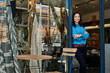 © mavoimages - Smiling Asian entrepreneur standing at the entrance of her boutique