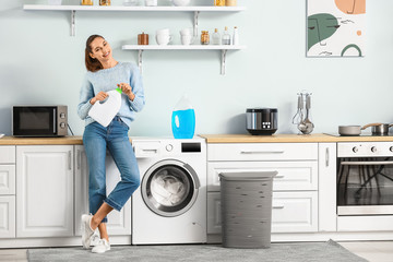 Wall Mural - Young woman doing laundry at home