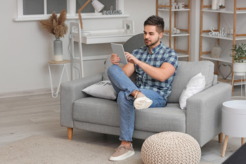 Canvas Print - Young man with tablet computer at home