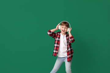 Poster - Cute little girl dancing and listening to music against color background