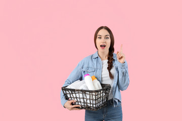 Sticker - Beautiful young woman with laundry and detergents on color background