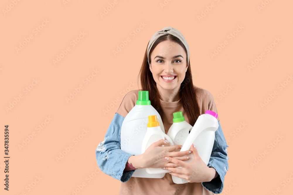 Beautiful young woman with detergents on color background