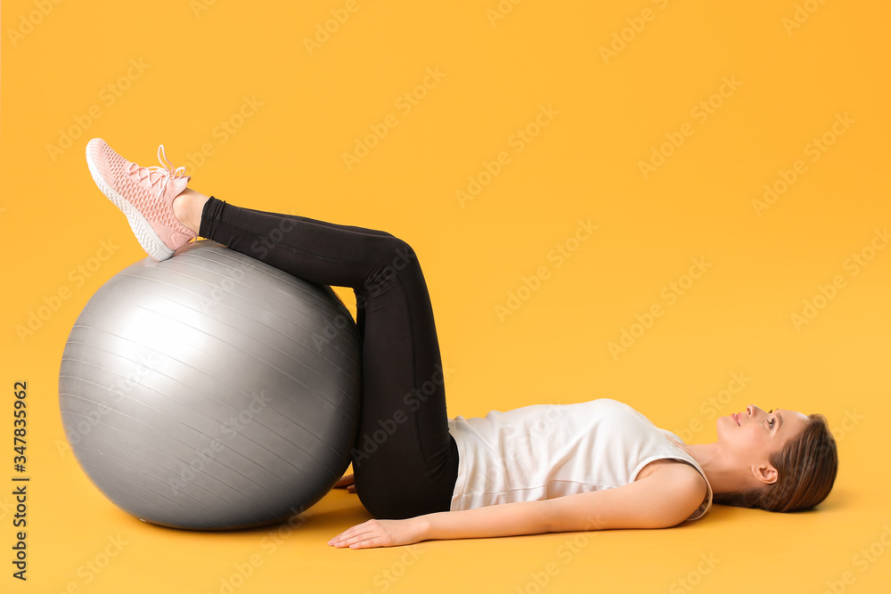 Sporty young woman training against color background