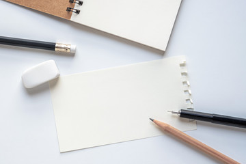 Wall Mural - close up. blank paper sheet with pencil, eraser and open spiral notebook on white background. empty 