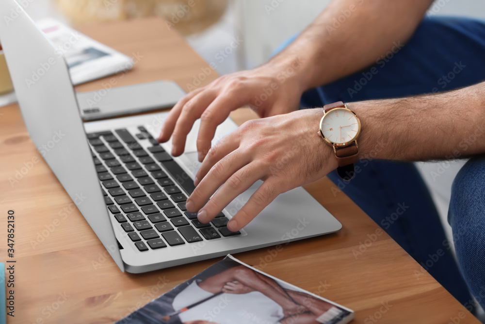 Young man with laptop working at home