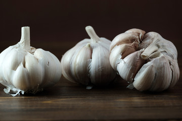 old garlic on a brown wooden surface