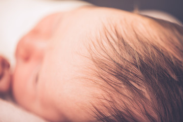 Newborn baby face close up shallow depth of field. Close-up beautiful sleeping baby girl.