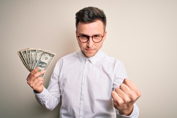 Wall Mural - Young handsome caucasian business man holding bunch of one dollar banknotes annoyed and frustrated shouting with anger, crazy and yelling with raised hand, anger concept