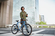 © StratfordProductions - young man with blue cycle standing using smartphone while looking away