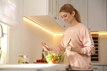 Poster - Young woman cooking salad at counter in kitchen