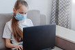 © Екатерина Говорина - Distance learning online education. School girl in medical mask studying at home with digital tablet laptop notebook