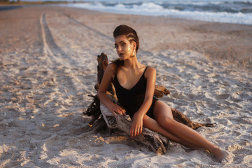 Slim tanned model on the beach. Beautiful makeup t hairstyle. sea ​​holiday