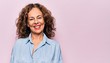 Middle age beautiful woman wearing casual denim shirt standing over pink background with a happy and cool smile on face. Lucky person.