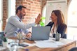 © Krakenimages.com - Two middle age business workers smiling happy and confident. Working together with smile on face hand giving high five at the office