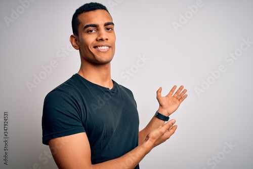 Fotomural Young handsome african american man wearing casual t-shirt standing over white b