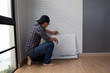 © comzeal - Young Asian man glueing wallpapers on the wall at home. renovation room in house by self diy concept