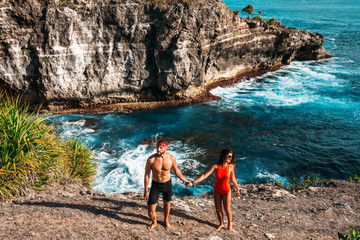 A couple in love on the beach. Beautiful couple by the sea on the island of Bali. A single couple on an island in Indonesia. Honeymoon trip. A man and a woman travel in Asia. Happy couple on vacation