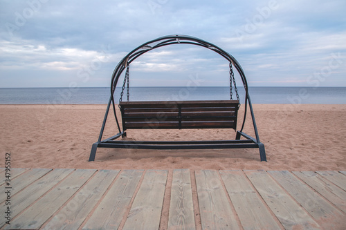 Fotografía Lonely swings on the sandy shore of Lake Ladoga. Without people.