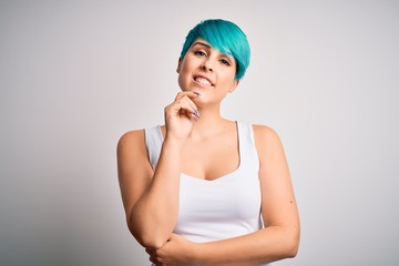 Sticker - Young beautiful woman with blue fashion hair wearing casual t-shirt over white background looking confident at the camera smiling with crossed arms and hand raised on chin. Thinking positive.