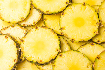 Pineapple juicy yellow slices background. Top view.