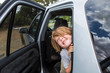 © Marc Romanelli - 6 year old boy leaning out of stationary SUV