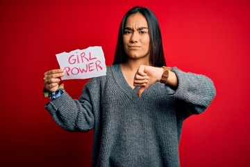 Canvas Print - Young beautiful asian woman holding banner with girl power message over red background with angry face, negative sign showing dislike with thumbs down, rejection concept