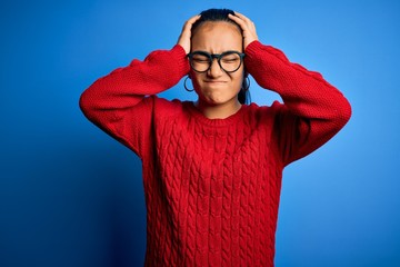 Canvas Print - Young beautiful asian woman wearing casual sweater and glasses over blue background suffering from headache desperate and stressed because pain and migraine. Hands on head.