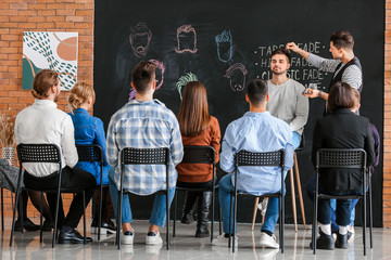 Wall Mural - Professional hairdresser teaching young people in salon