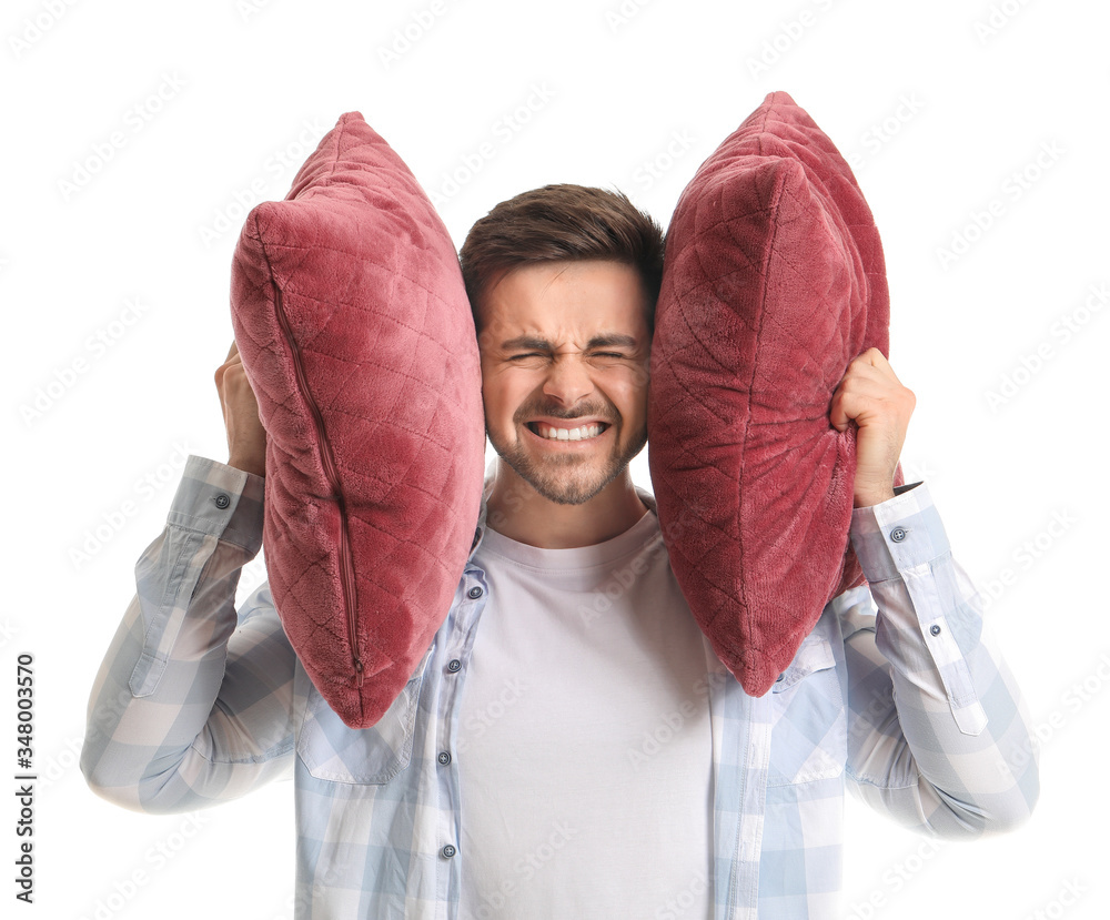 Young man suffering from loud noise on white background