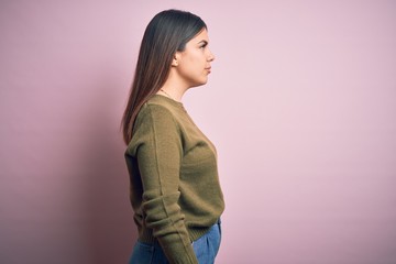 Sticker - Young beautiful woman wearing casual sweater standing over isolated pink background looking to side, relax profile pose with natural face with confident smile.