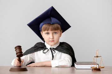 Sticker - Portrait of little judge sitting at table against grey background