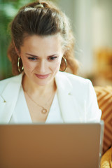 happy modern woman with laptop in modern house in sunny day