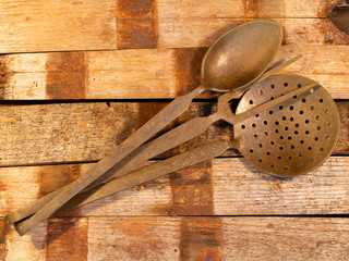 old cutlery on a wooden table with spoons and forks.spoons, forks, knives, ladles on a wooden table, selective focus and toned image