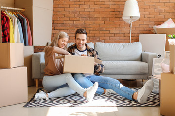 Wall Mural - Young couple unpacking things in their new flat on moving day