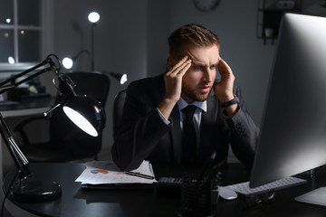 Poster - Tired businessman working in office late at night