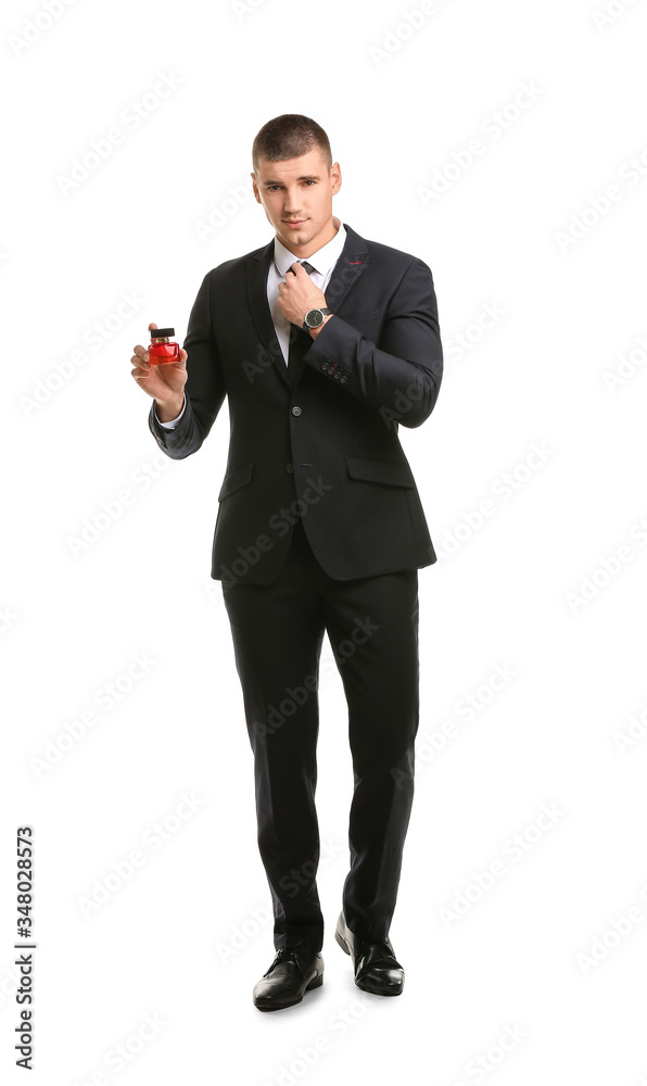Handsome young man with bottle of perfume on white background