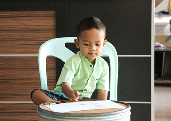 Wall Mural - The patient kid is painting the paper with a color pencil.