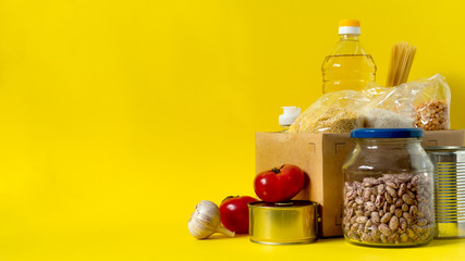 Banner.Donation. Food supplies crisis food stock for quarantine isolation period on yellow background. Rice, peas, cereals, canned food, oil, vegetables, mask, sanitizer. Food delivery. Cope space.