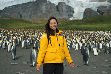 woman standing in front of penguin colony
