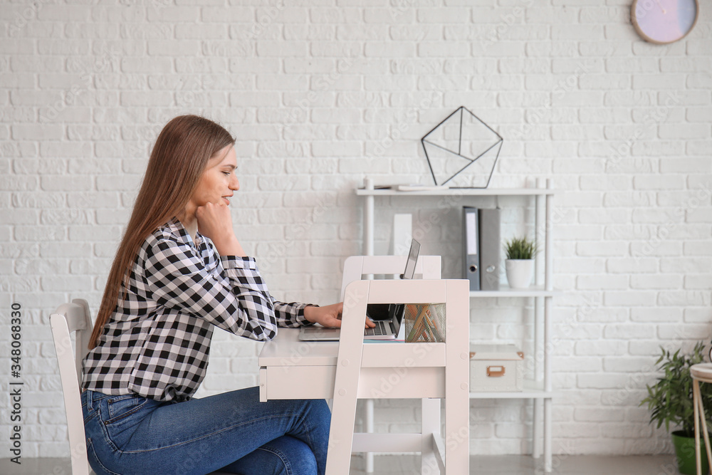 Young woman with laptop working at home