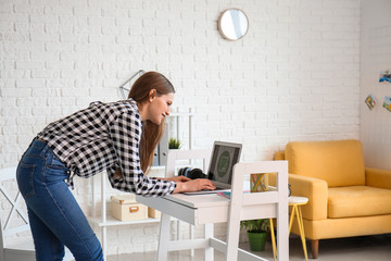 Sticker - Young female designer with laptop working at home