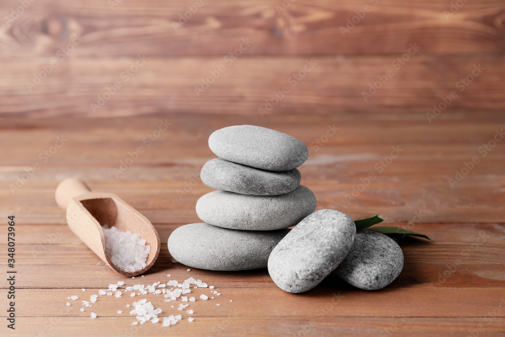 Spa stones and sea salt on wooden background
