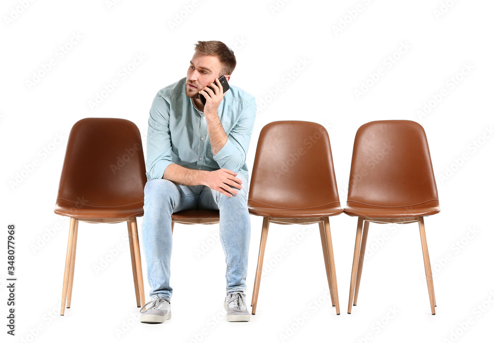Young man waiting for his turn on white background