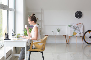 Canvas Print - Young woman with laptop working at home