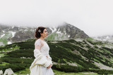 Fototapeta Konie - Beautiful bride in the mountains. Wedding photo shoot in the mountains.