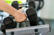 © Leo Lintang - Man hand taking dumbbell on a rack