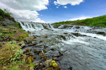 Wall Mural - The beautiful and amazing bruarfoss waterfall in Iceland, the turquoise water stream. Green trees and blue skies in summer Here is a hidden waterfall in a secret place.